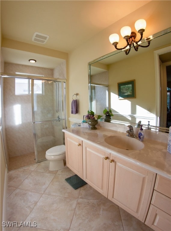 bathroom with tile patterned flooring, vanity, walk in shower, and an inviting chandelier