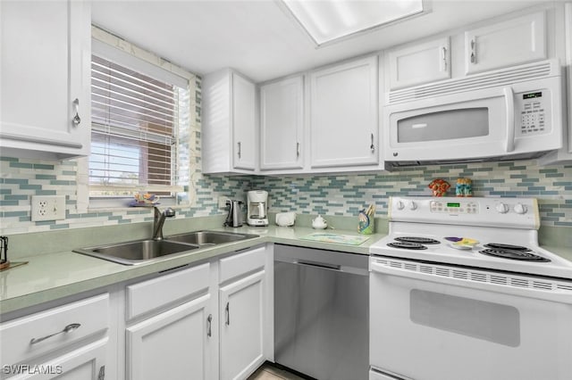 kitchen with white appliances, white cabinetry, and sink