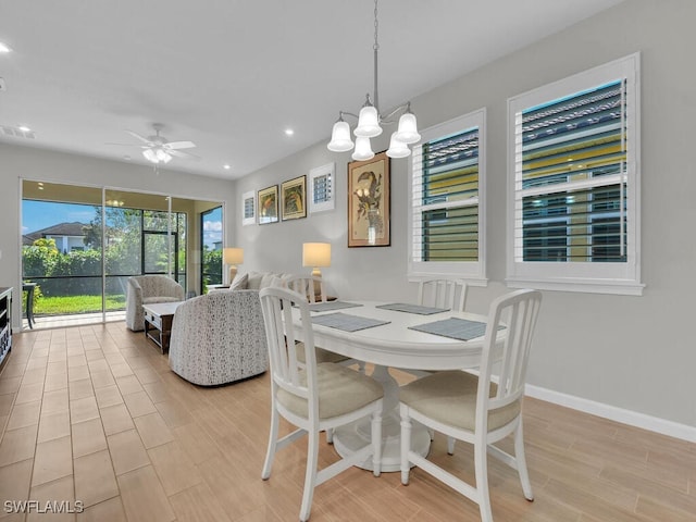 dining area featuring ceiling fan with notable chandelier and light wood-type flooring