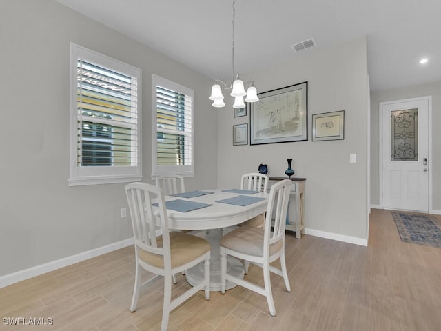 dining area with a chandelier and light hardwood / wood-style floors