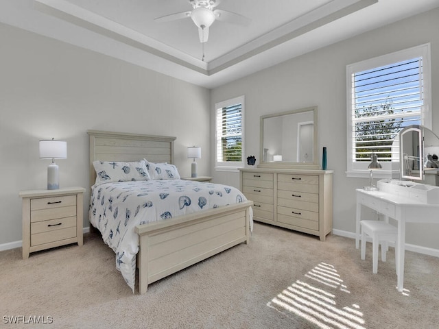 bedroom with multiple windows, ceiling fan, and light carpet