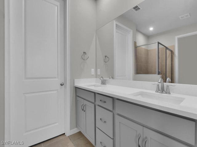 bathroom with tile patterned flooring, vanity, and a shower with door