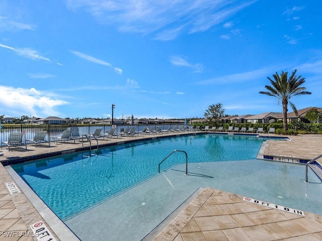 view of swimming pool with a patio area and a water view