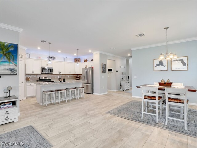 dining space with visible vents, ornamental molding, baseboards, a chandelier, and wood tiled floor