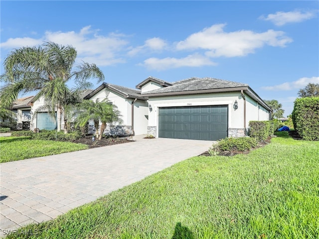 view of front of property featuring driveway, an attached garage, stucco siding, a front lawn, and stone siding