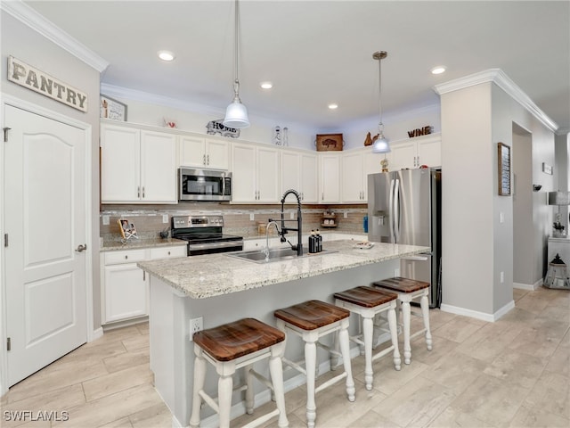 19431 Elston Way, Estero, FL 33928 - kitchen with appliances with stainless steel finishes, decorative backsplash, ornamental molding, white cabinets, and a breakfast bar area