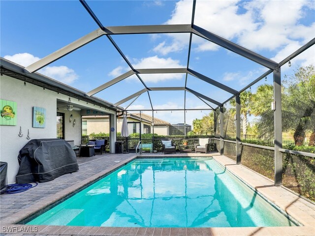 view of pool featuring a lanai, a fenced in pool, a grill, and a patio