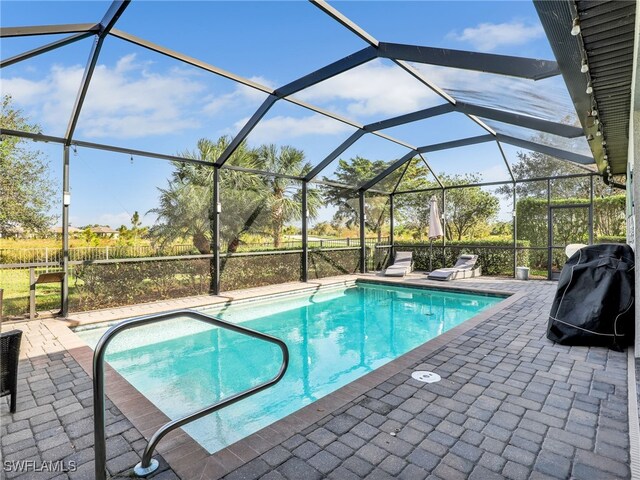 view of swimming pool featuring a patio and glass enclosure