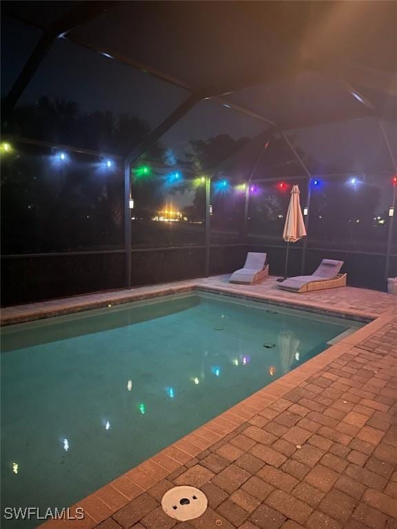 pool at twilight with a patio area