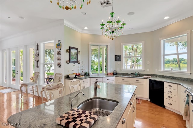 kitchen featuring dishwasher, light stone countertops, and a wealth of natural light