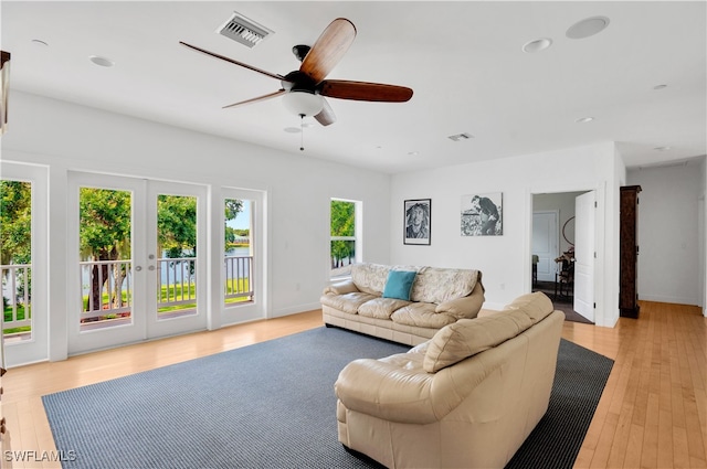 living room featuring ceiling fan, french doors, and light wood-type flooring