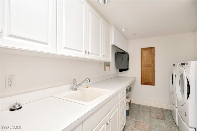 laundry room with cabinets, separate washer and dryer, and sink