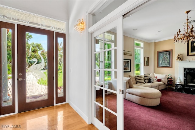 doorway with a premium fireplace, crown molding, and light hardwood / wood-style flooring