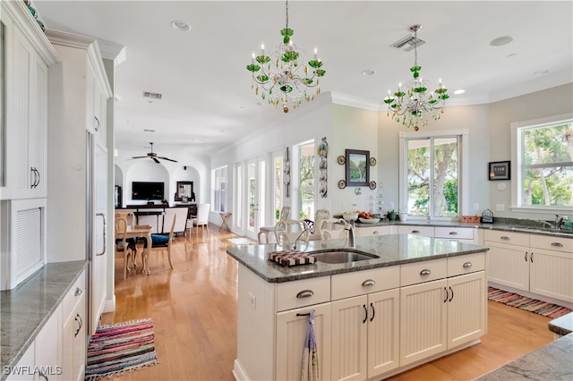 kitchen featuring dark stone countertops, pendant lighting, and light hardwood / wood-style floors