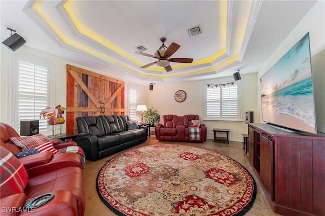 living room featuring a tray ceiling, ceiling fan, and ornamental molding