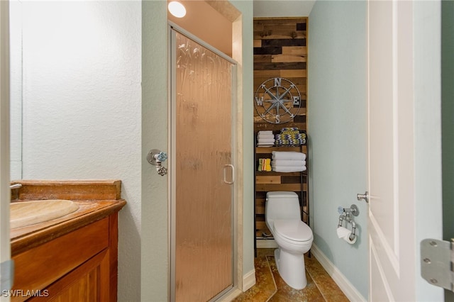 bathroom with vanity, toilet, and a shower with door