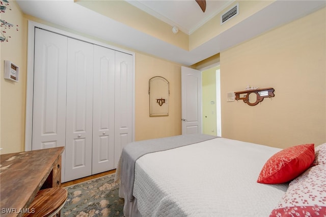 bedroom with hardwood / wood-style floors, ceiling fan, crown molding, and a closet