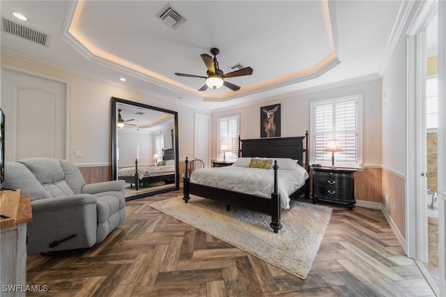 bedroom with ceiling fan, parquet flooring, and a tray ceiling