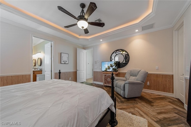 bedroom featuring parquet floors, a raised ceiling, ceiling fan, crown molding, and connected bathroom