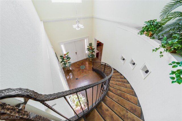 staircase with a towering ceiling and an inviting chandelier