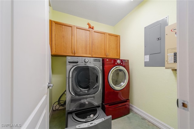 laundry room featuring electric panel, washer and clothes dryer, and cabinets