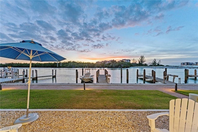 dock area featuring a lawn and a water view