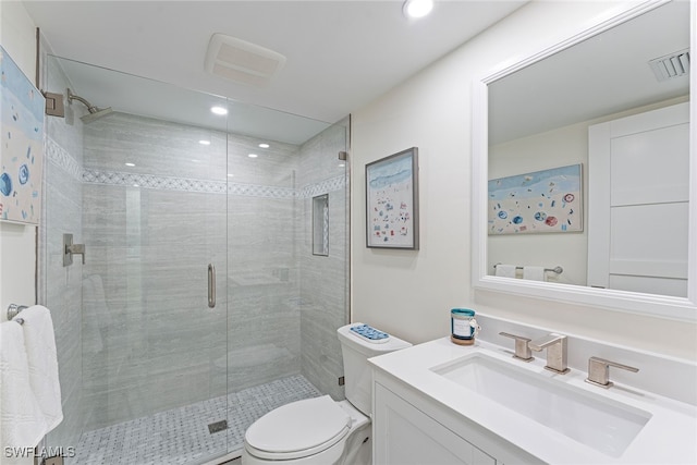 bathroom featuring vanity, an enclosed shower, and toilet