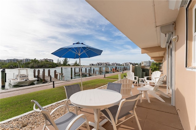 view of patio with a water view and a dock