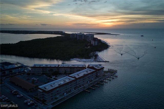 aerial view at dusk featuring a water view