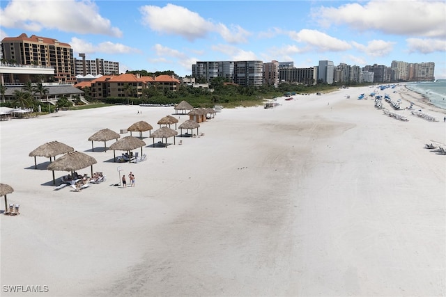 birds eye view of property featuring a water view and a beach view