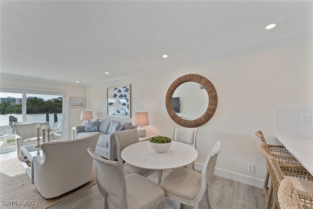 dining area with a water view and ornamental molding