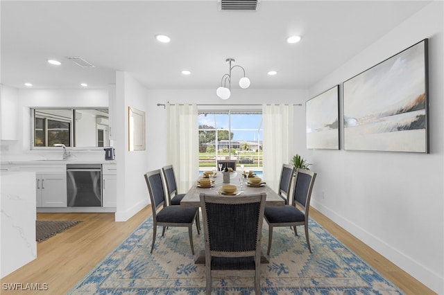 dining area featuring light wood-type flooring and sink