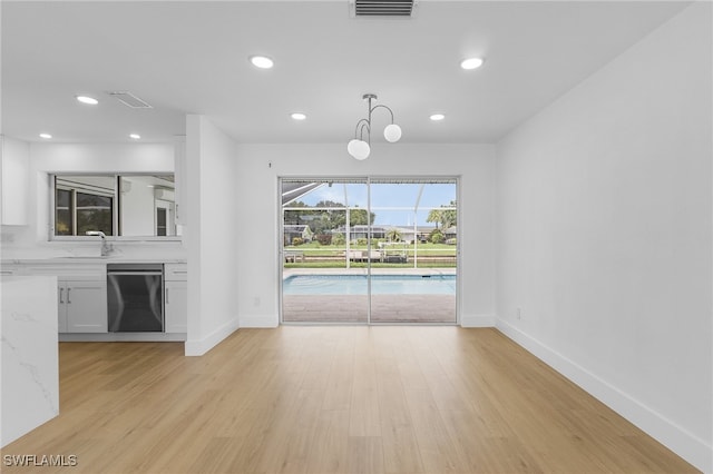 unfurnished living room with light hardwood / wood-style flooring and sink