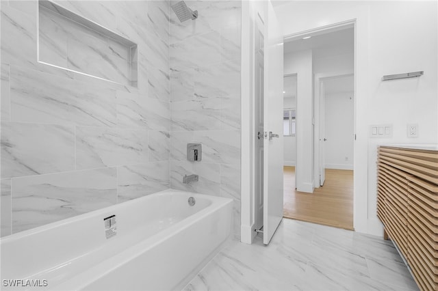 bathroom with tiled shower / bath combo and hardwood / wood-style flooring