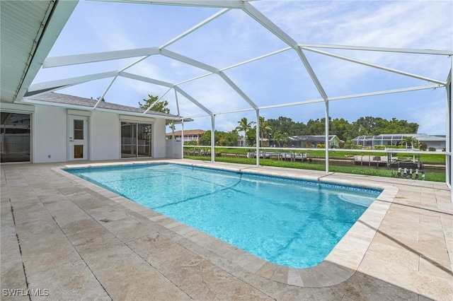 view of pool with glass enclosure and a patio area