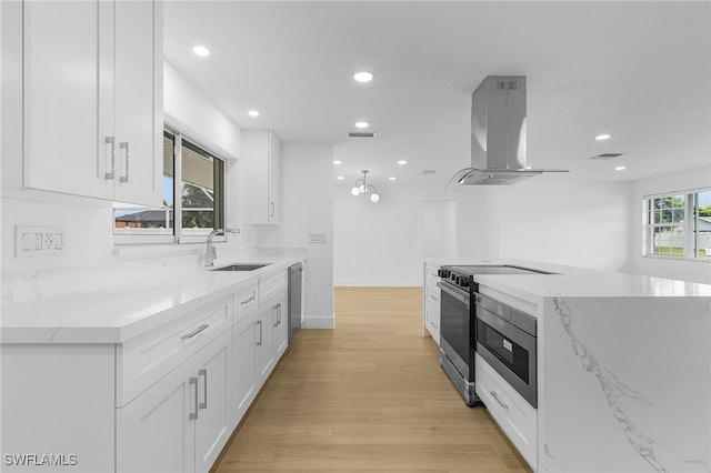 kitchen with white cabinets, appliances with stainless steel finishes, ventilation hood, and a wealth of natural light