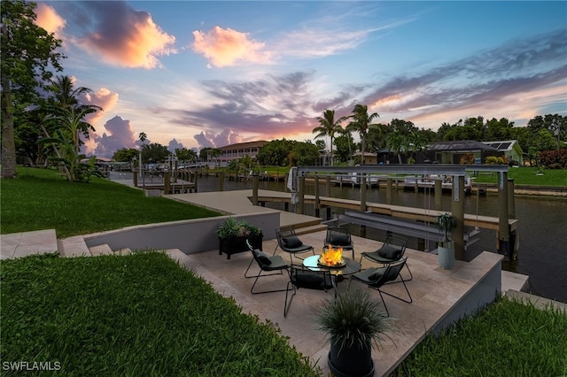 exterior space with a lawn, a water view, and a dock