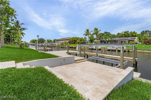 view of dock with a yard and a water view