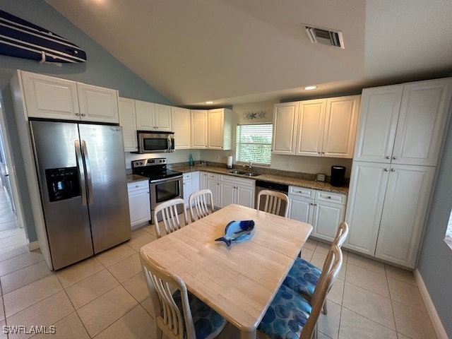 kitchen with white cabinets, light tile patterned floors, sink, and appliances with stainless steel finishes