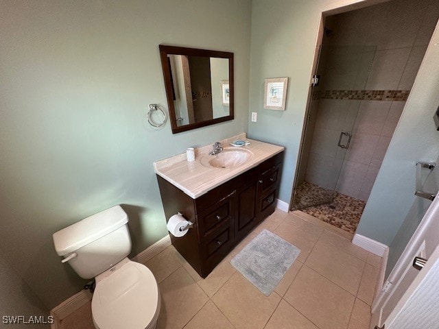 bathroom with tile patterned floors, vanity, an enclosed shower, and toilet