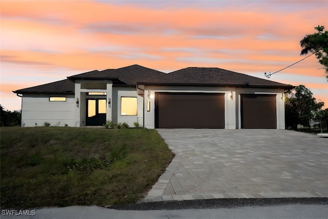 prairie-style home featuring a yard and a garage