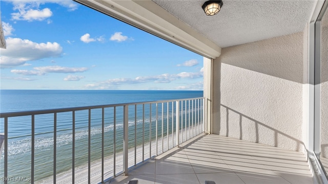 balcony with a water view and a beach view