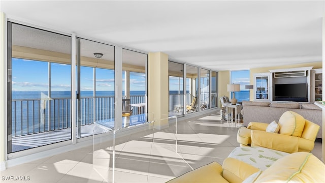 living room with plenty of natural light, a water view, and light tile patterned floors