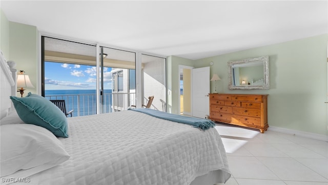 bedroom featuring access to outside, a water view, and light tile patterned floors