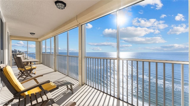 sunroom / solarium featuring a water view