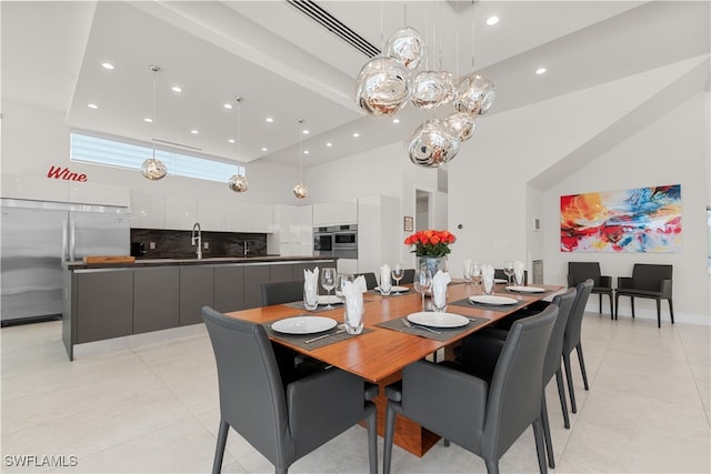 dining space with a high ceiling, light tile patterned floors, and sink