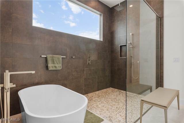 bathroom with tile patterned floors and shower with separate bathtub