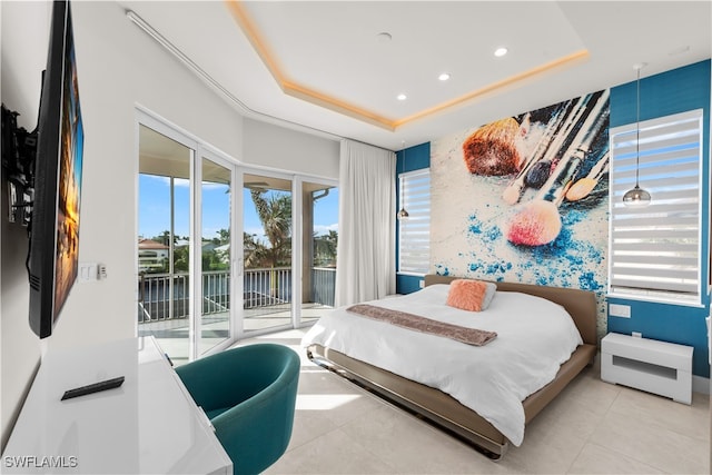 bedroom featuring access to exterior and a tray ceiling