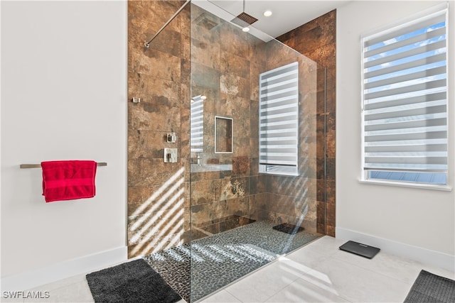 bathroom featuring tile patterned flooring and tiled shower