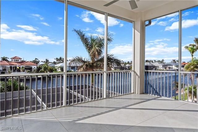 unfurnished sunroom with a water view and ceiling fan